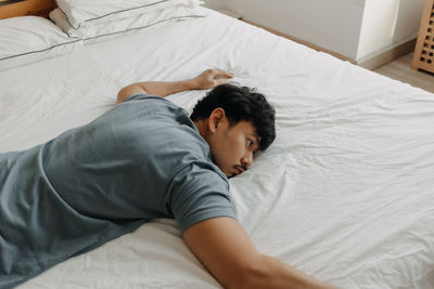 High angle view of man sleeping on bed