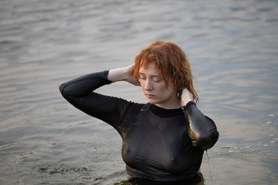 Portrait of young woman standing at beach