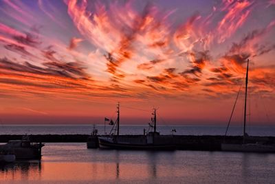 Sailboats in sea against sky during sunset