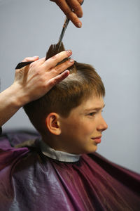 Profile portrait of a ten year old caucasian boy having his hair cut