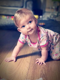 Portrait of cute baby girl  on floor at home