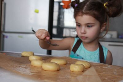 Close-up of girl eating food at home