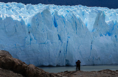 People standing in front of glacier