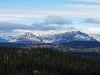 Scenic view of field in front of mountains against sky