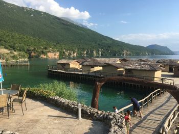 People on mountain by lake against sky