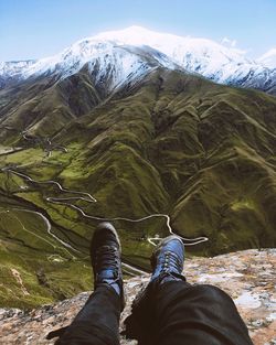 Low section of man sitting on mountain