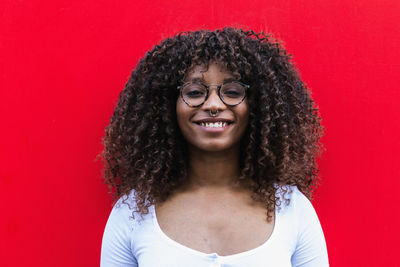 Portrait of smiling woman against red background