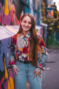 Portrait of smiling young woman standing in city