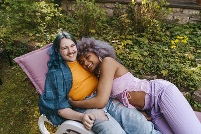 High angle view of lgbtq friends relaxing on chair in back yard