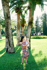 Low angle view of women standing by tree