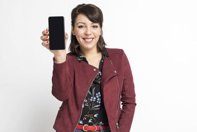 Young woman using mobile phone against white background