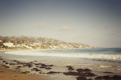 Sea by cityscape against sky