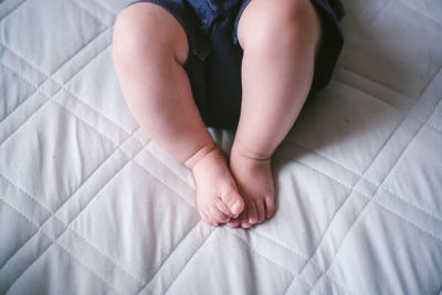 Low section of baby feet on bed