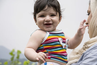 Portrait of happy boy holding baby