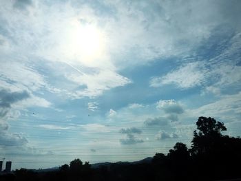 Silhouette trees against cloudy sky