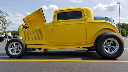 Yellow car on road against sky