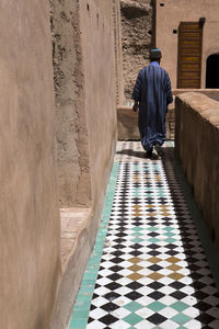 Rear view of man walking by building