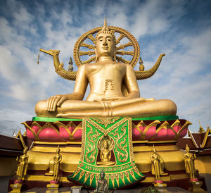 Low angle view of statue against temple against sky