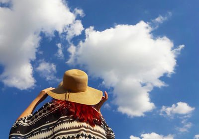Low angle view of person against blue sky