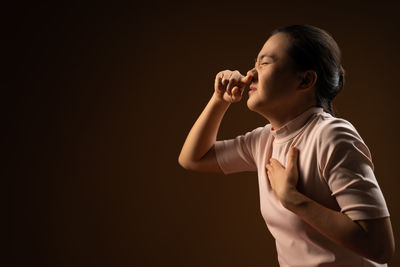 Side view of a girl looking away against black background
