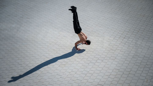 High angle view of man doing handstand on street