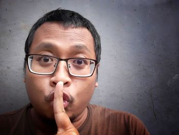 Close-up portrait of teenage boy against wall