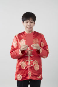 Smiling man holding umbrella against white background