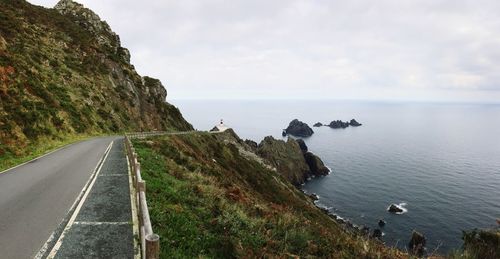 Scenic view of sea by cliff against sky