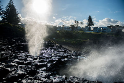 Scenic view of waterfall against sky