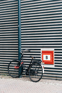 Bicycle parked against brick wall