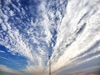 Low angle view of street light against cloudy sky