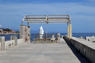 Rear view of building by sea against sky