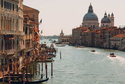 Boats in canal amidst buildings in city