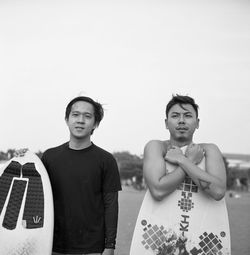 Young friends with surfboards at beach