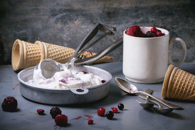 High angle view of ice cream cones by frozen berries on table