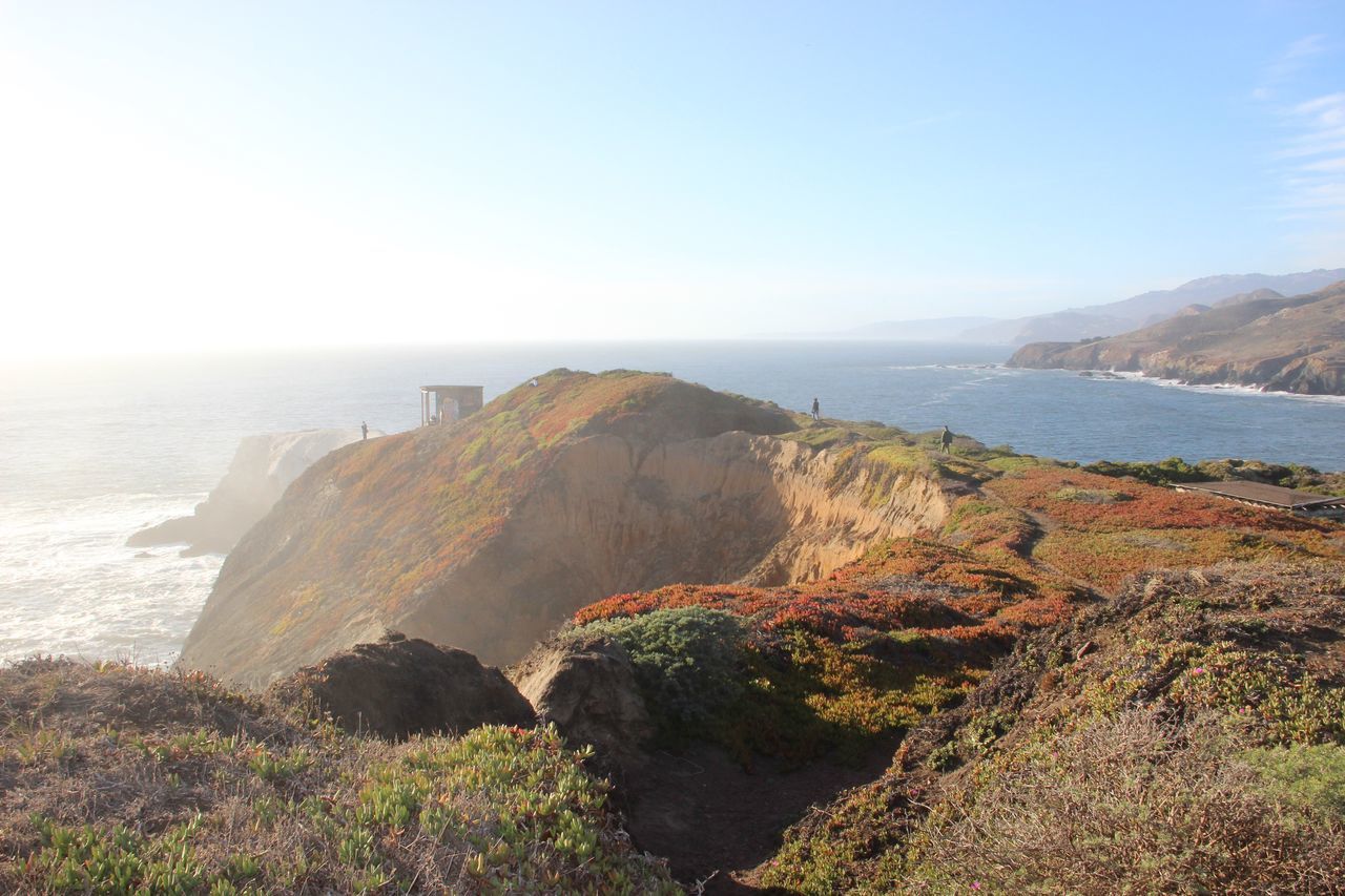 sea, water, horizon over water, scenics, beauty in nature, tranquil scene, tranquility, clear sky, nature, idyllic, coastline, cliff, plant, remote, day, mountain, non-urban scene, outdoors, calm, blue, seascape, rock formation, sky, shore, no people, geology, rocky, multi colored, green color