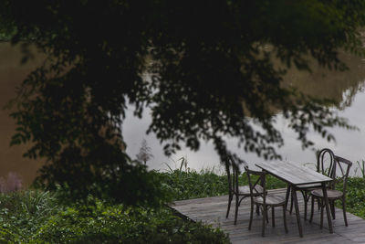 Empty bench and table in park against sky