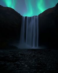 Scenic view of waterfall against sky at night