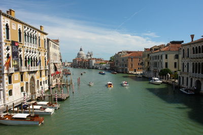 Boats in canal amidst buildings in city