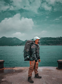 Full length of man standing by lake against sky