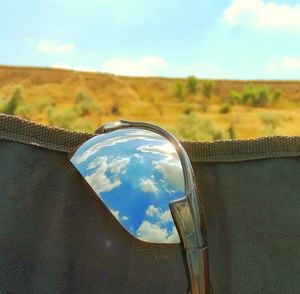 Close-up of reflection on landscape against sky