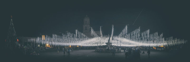 People on illuminated city at night