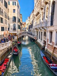 Boats in canal amidst buildings in city