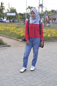 Portrait of girl standing on footpath