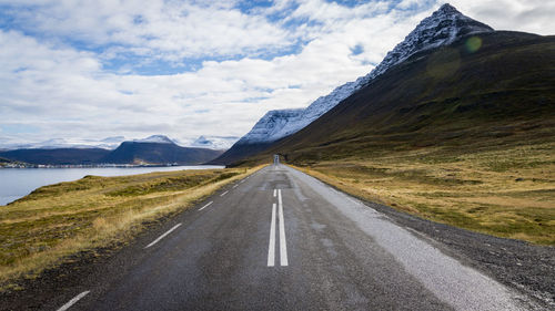 Road by mountain against sky