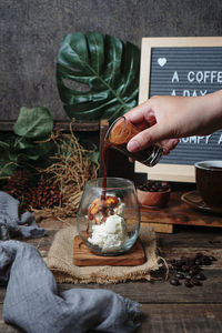 Hand holding ice cream on table