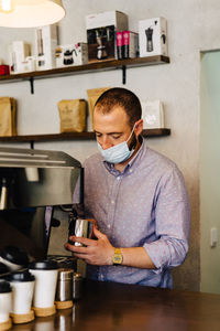 Portrait of young barista preparing a cappuccino