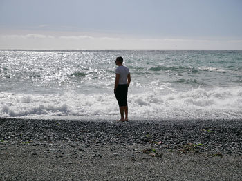 Rear view of man standing on beach