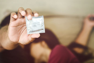 Close-up of man holding condom
