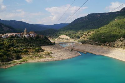 Scenic view of river by mountains against sky